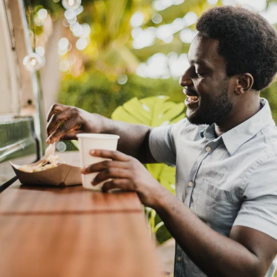 Image of a person eating out of a food truck bench