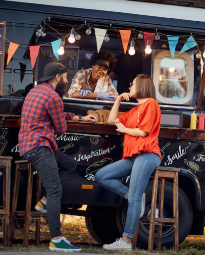 Food truck operator talking to two customers