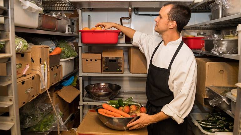 chef picking produce out of the walk-in fridge