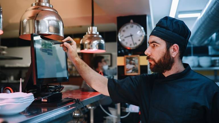 chef checking orders on kitchen display system