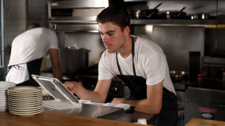 line cook checking orders on iPad