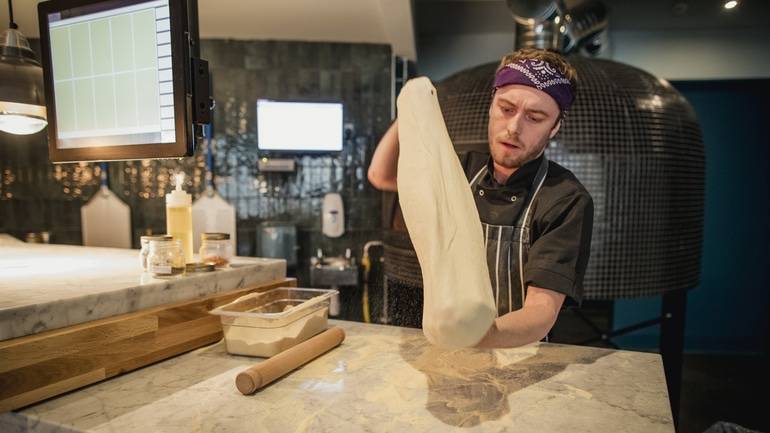 chef stretching pizza dough