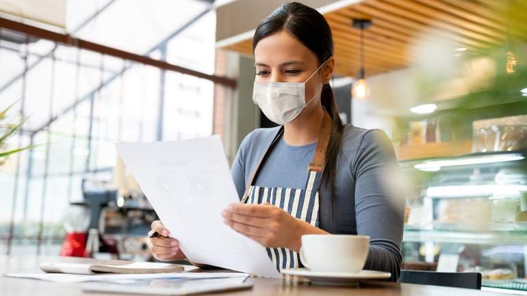 restaurant owner reviewing paperwork wearing mask