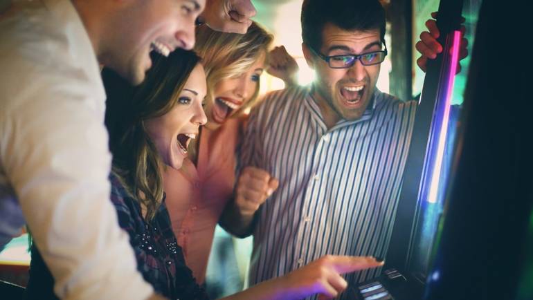 patrons gathered around an arcade game