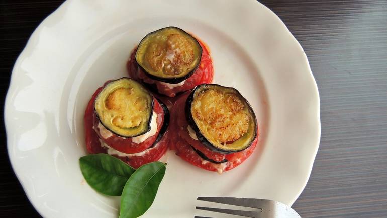 ratatouille plated in rose shapes with fresh herbs