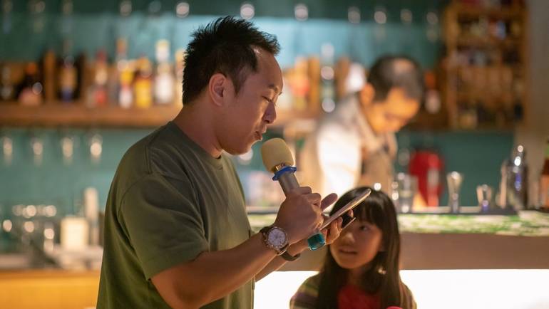 man reading trivia questions on a microphone