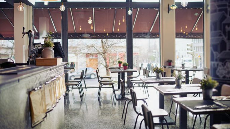 A clean empty and open restaurant dining room showing floor plan of tables.