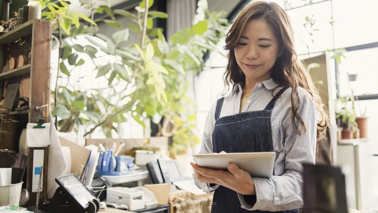 Woman working in a flower shop using an iPad POS system