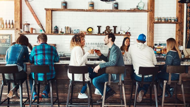 customers seated at a long bar enjoying the music