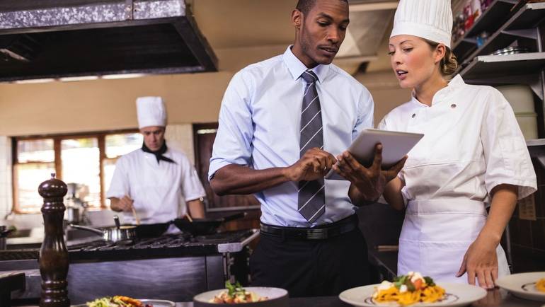 restaurant manager reviewing food cost with back of house staff