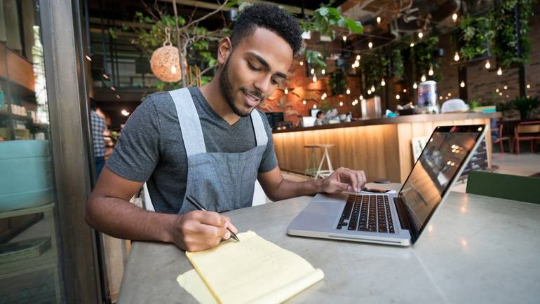 restaurant manager taking notes from laptop