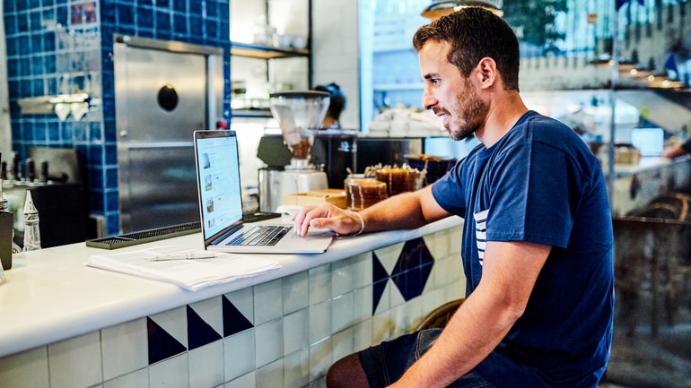Restaurant owner using a laptop on a restaurant counter