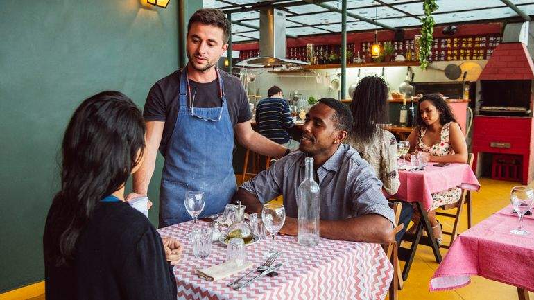 server visiting the table of two diners