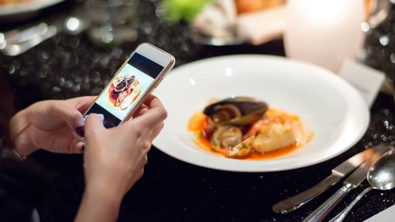 photographing a seafood dish with a smart phone