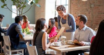 server taking the order of two diners