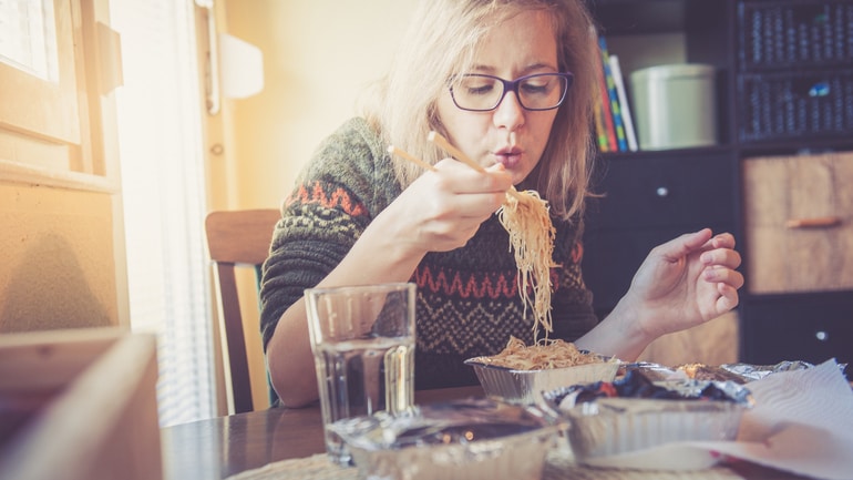 customer eating noodles in a take away container