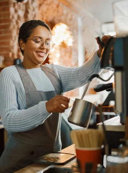 An image of a coffee shop employee making coffee