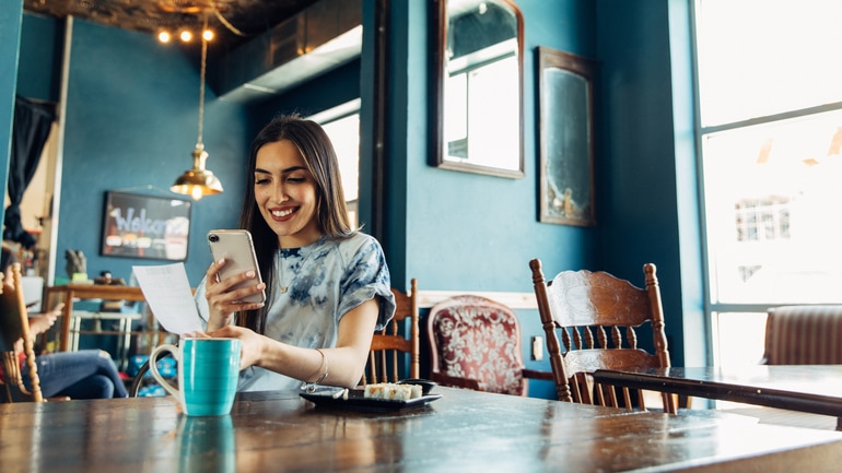 Woman using her smartphone to access a restaurant loyalty program
