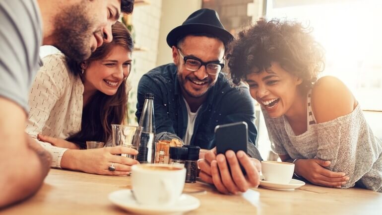 Group of friends looking at a smartphone screen in a cafe
gamification