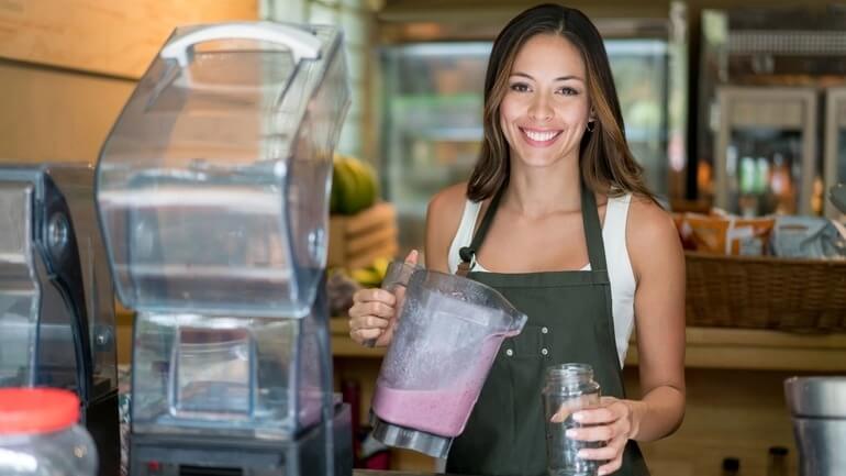 Woman serving smoothies at a cafe