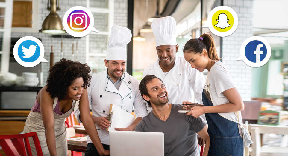 restaurant employees looking at social media platforms on a laptop