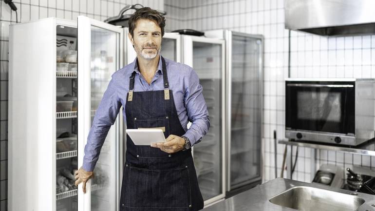 restaurant manager using POS in restaurant kitchen