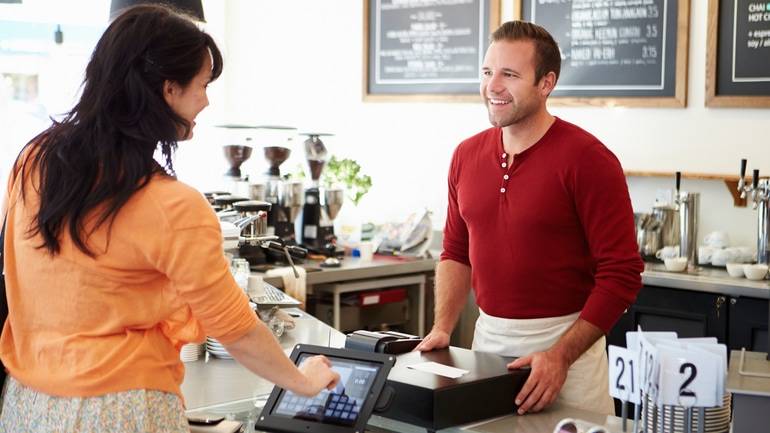 customer ordering from self-serve kiosk at a counter top