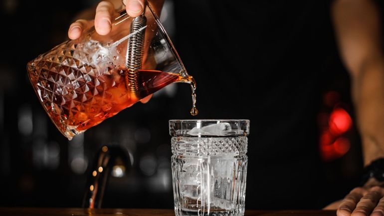bartender straining a cocktail
