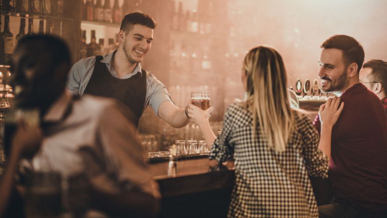 smiling bartender serving a drink