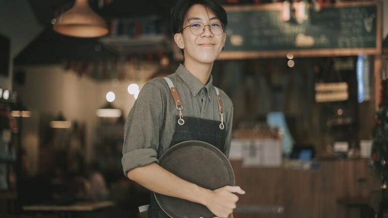 Teenage boy waiter in a restaurant