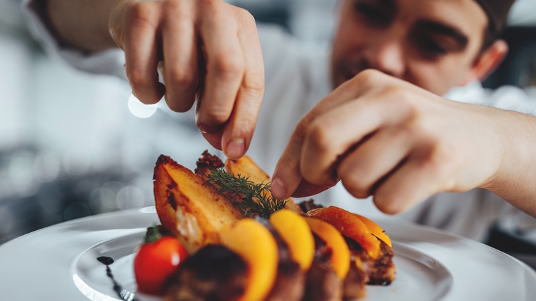 chef arranging garnishes on a plate