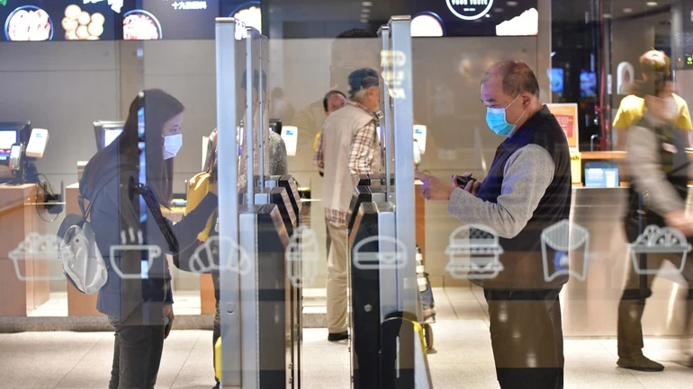 Customers using restaurant kiosks to place their orders