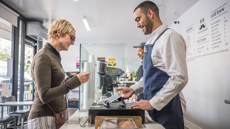 Female customer using a customer display at a cafe