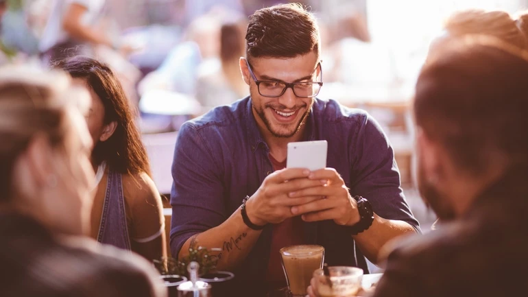 Man at coffee shop using a mobile phone