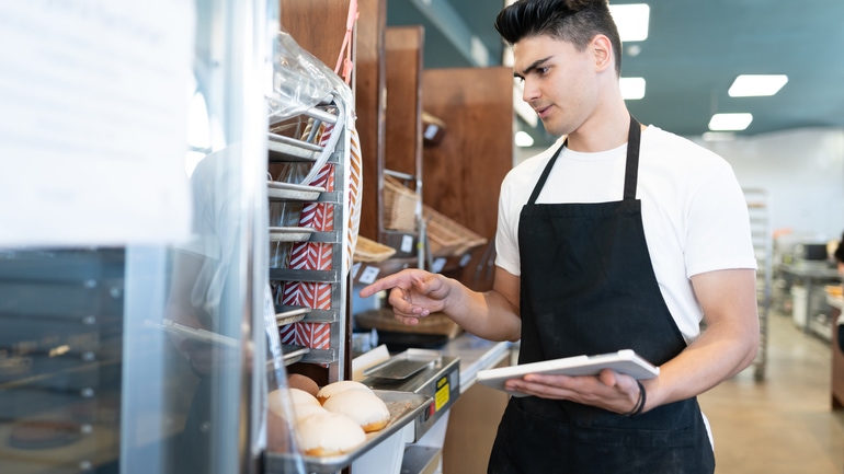 Worker doing inventory at a bakery.