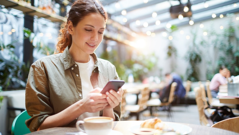 Woman checking her phone in a restaurant.