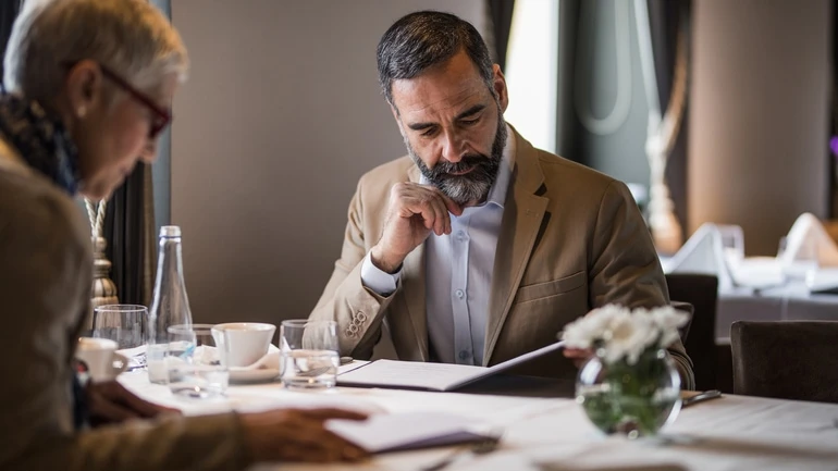 Couple reading a menu in a fine dining restaurant.