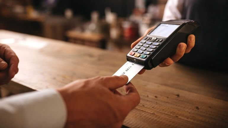 Customer paying with a credit card in a cafe.