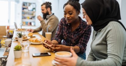 Two women using a mobile restaurant loyalty program