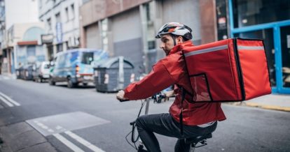 Courier on a bike with a food delivery bag