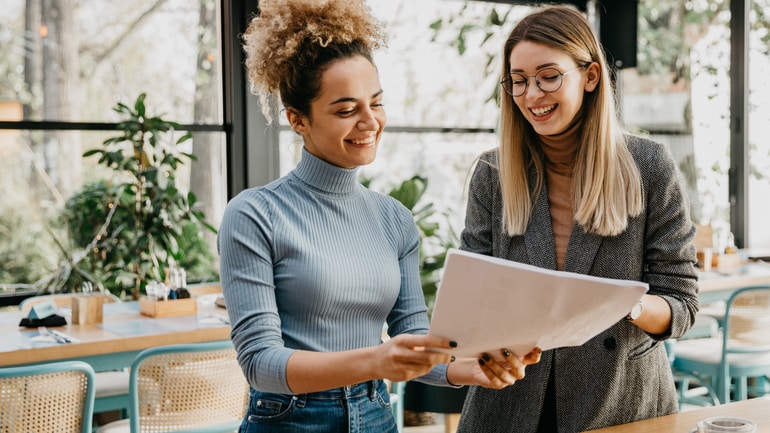 Two women reviewing a restaurant business plan.