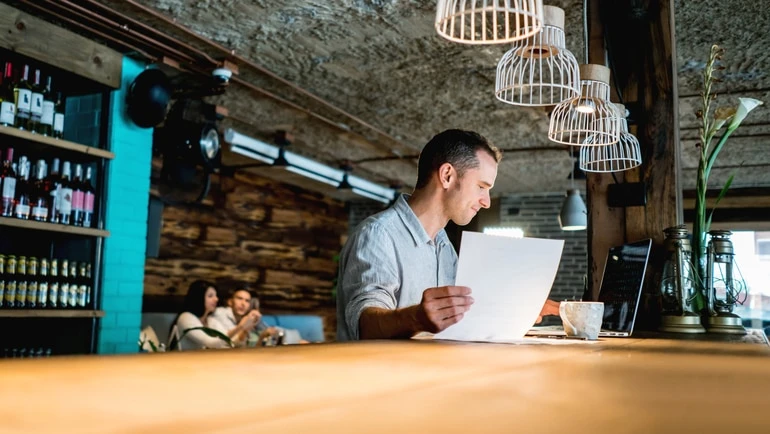 Man reviewing business plans in a restaurant.