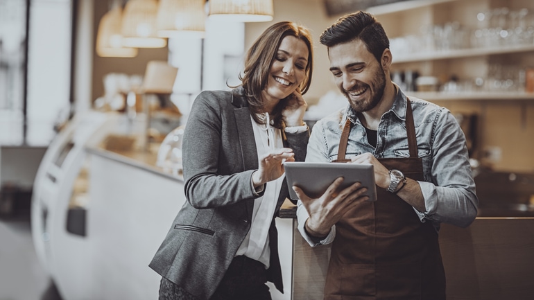 Two restaurant workers using a tablet.