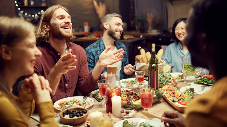 People laughing at a dinner at a restaurant.