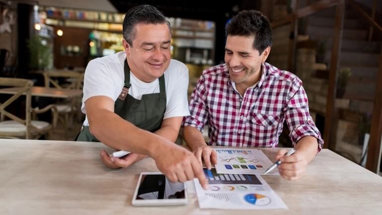 two men working at a restaurant look at finances 
