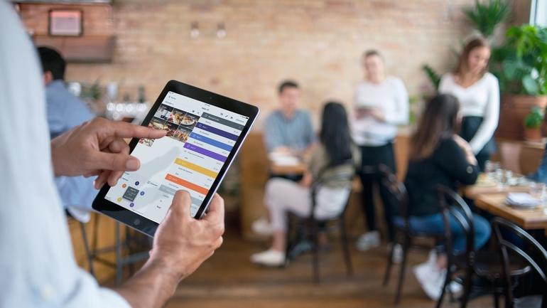 Restaurant worker uses TouchBistro restaurant management system on a tablet.