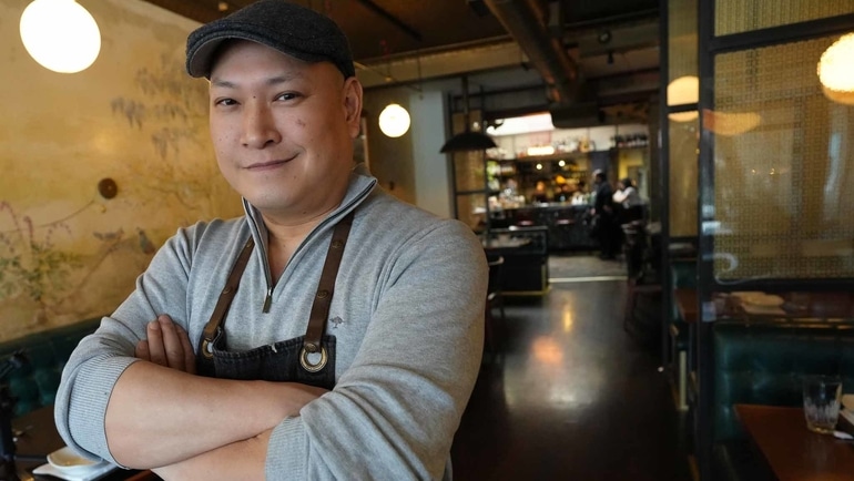 DaiLo restaurant Owner and Chef Nick Liu standing in his restaurant with his arms crossed.