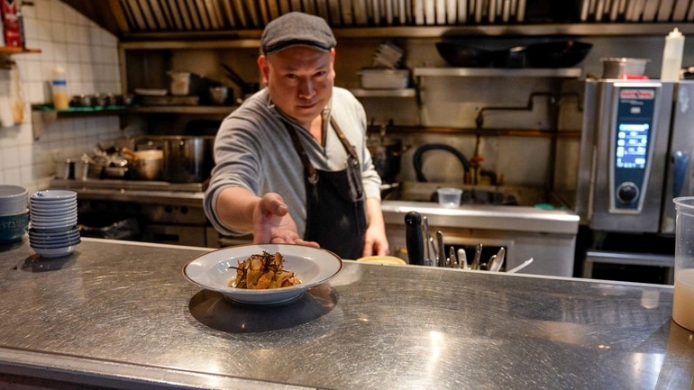 DaiLo Chef Nick Liu serving up a meal in the restaurant's kitchen.
