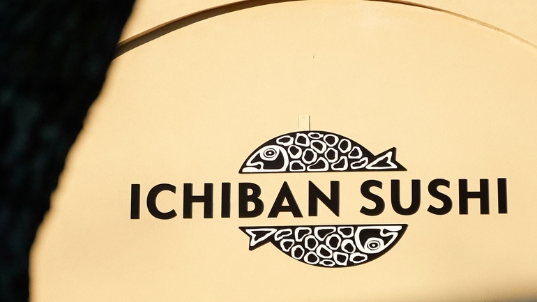 Yellow building exterior showing the black and white fish-shaped logo for the Ichiban Sushi restaurant.