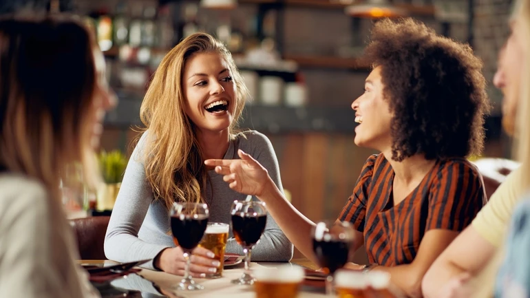 Group of friends enjoying wine and beer at a restaurant.